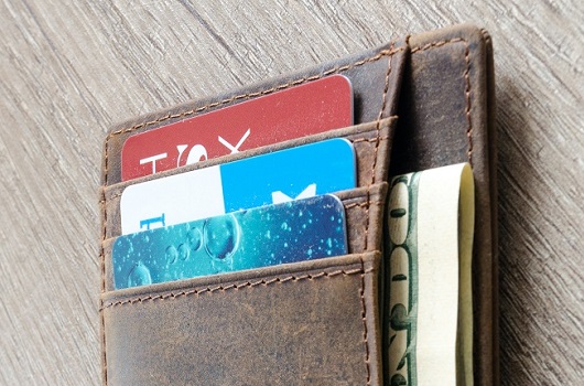 brown wallet with cash and credit cards