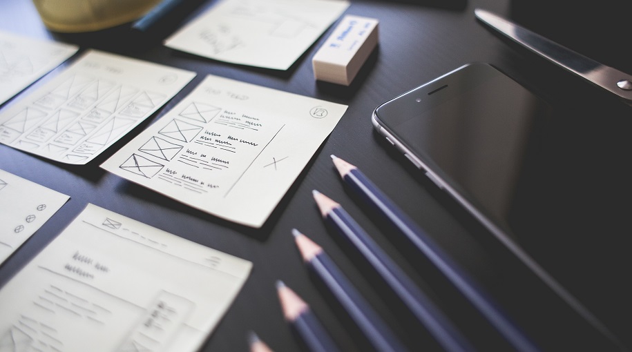 desk with paper, pencils and smartphone