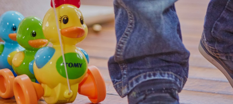 child pulling duck toy with Tomy logo