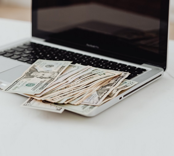 laptop with money on the keyboard