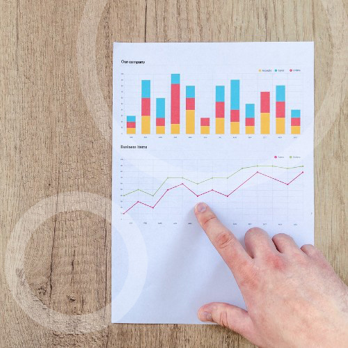 person pointing on paper line graph