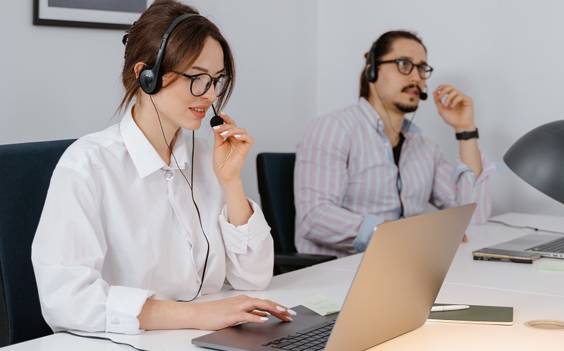 co-workers on headsets with laptops