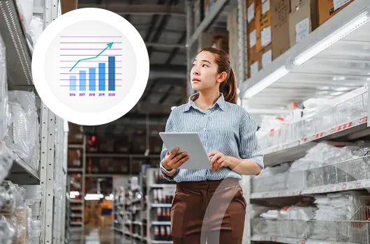 woman with tablet walking down warehouse aisle